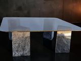 a glass table with a marble base on a black floor