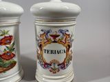 pair of ceramic jars with floral designs on them sitting on a table