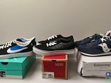 three pairs of shoes are sitting on top of boxes on a table
