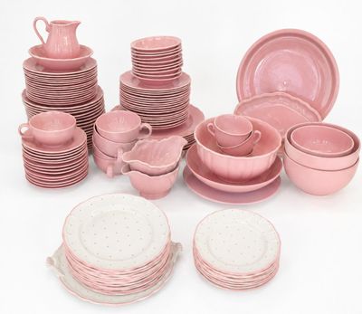de nombreux plats, tasses et assiettes roses sur la table