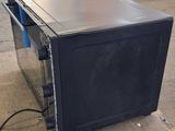 a black microwave sitting on a pallet in a warehouse