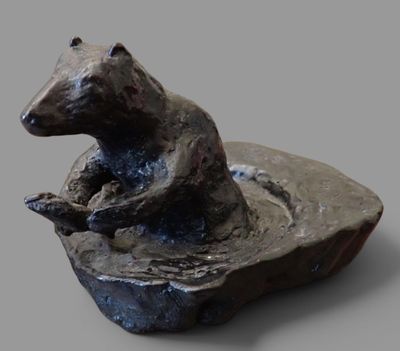 une statue représentant un ours assis sur un rocher
