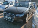 une Audi noire garée sur un parking avec d'autres voitures