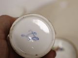 a person holding a small white bowl with a blue design on it