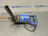 an image of a drill on a table in front of a sign