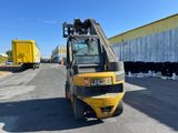 a yellow forklift truck parked in front of a building