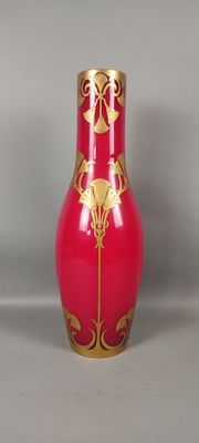 un vase rouge orné d'un motif doré