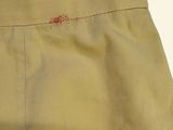 the back of a tan pants with a red spot on it