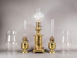 quatre types de verres différents et une lampe posée sur une table