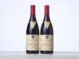two bottles of red wine sitting on top of a table