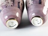 pair of purple vases sitting on top of a white table