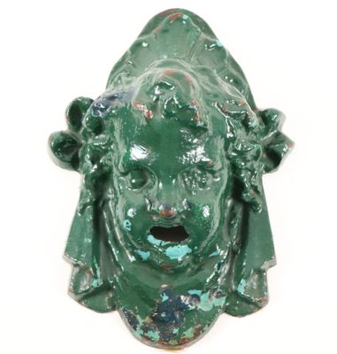 a green statue of a woman with a surprised face