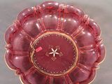 a red glass plate with a gold rim and a clock on it