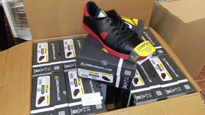 une boîte contenant une paire de chaussures noires et rouges