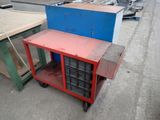 a red and blue cart sitting in the middle of a parking lot