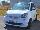 a small white car that is parked on the side of the road