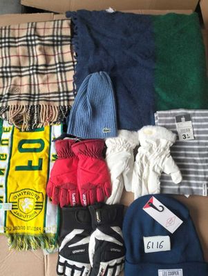 une boîte remplie de vêtements et de gants posée par terre