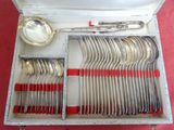 des couverts dans un coffret en argent avec des poignées rouges et des cuillères