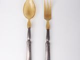 two spoons and a fork on a white table