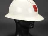 a white hard hat with a red cross on it