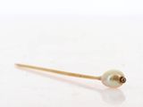 a gold stick with a pearl on it sitting on top of a table