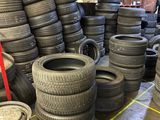 a lot of tires stacked on the floor in a warehouse
