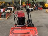une machine rouge qui se trouve au milieu d'un entrepôt