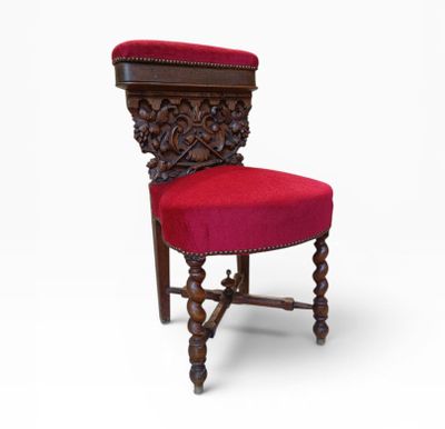 une vieille chaise avec une assise rembourrée rouge sur fond blanc