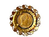 une assiette en or contenant une pièce de monnaie, sur fond blanc