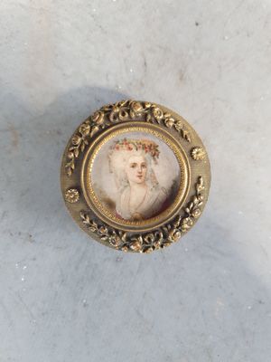 le portrait d'une femme dans un cadre doré posé sur une surface en marbre