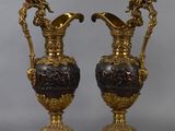 pair of antique bronze and black vases sitting on top of each other