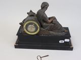 a statue of a woman sitting on a table with a clock in front of her