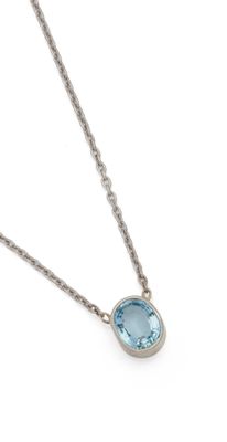 a necklace with a blue topaz stone is shown on a white background