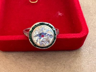 une photo d'une bague en diamant dans un écrin rouge posé sur une table