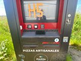 a black and red vending machine on the side of the road