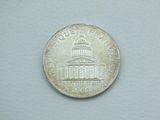 a close up of a coin with the capitol building in the background