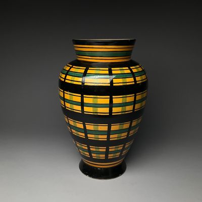 a vase that is sitting on a table with a black base