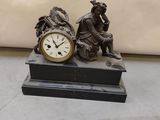 a statue of a man and a woman sitting next to a clock