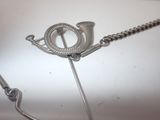 a silver necklace with a metal pin attached to it