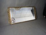 a mirror that is sitting on the ground with a person taking a picture
