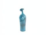 un vase bleu orné d'un oiseau sur fond blanc