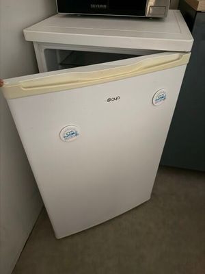 un micro-ondes posé sur un réfrigérateur, à côté d'un four à micro-ondes