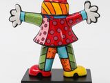 brightly colored figurine of a woman with arms outstretched