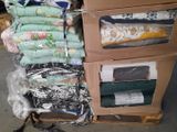 a stack of folded cloths on a cart in a warehouse