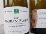 two bottles of wine sitting next to each other on a table
