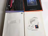 two books are open on a table with a red car in the background