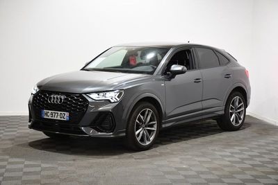 un SUV Audi gris garé sur un sol à damier