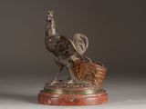 bronze statue of a bird with a basket on a marble base