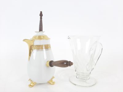 a white and gold coffee pot next to a glass vase