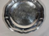 a silver plate on a white table with a black background